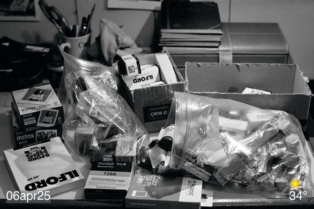 Black and white film photo of a bunch of film rolls