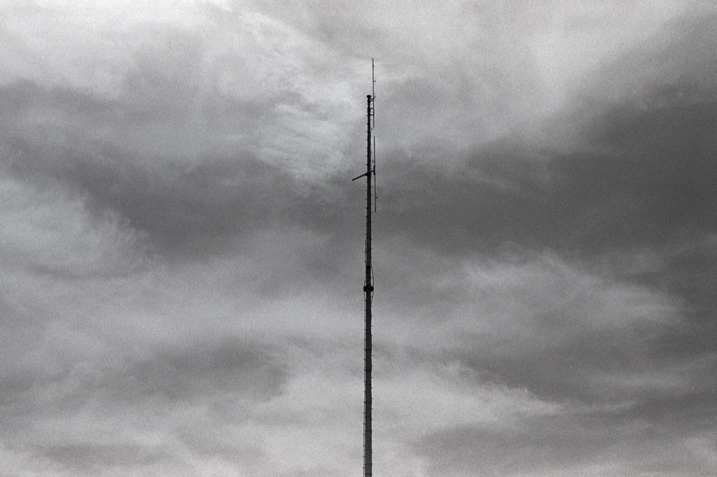 Black and white film photo of slim tower and sky