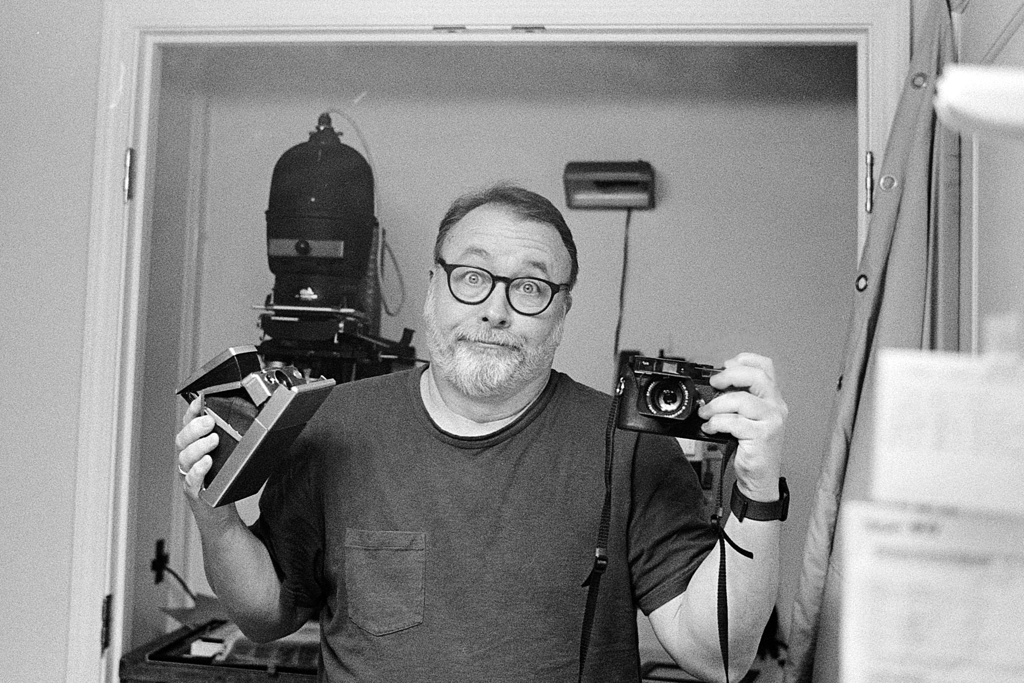 Self-portrait in mirror with Leica MP. I'm alo holding a Polaroid SX-70