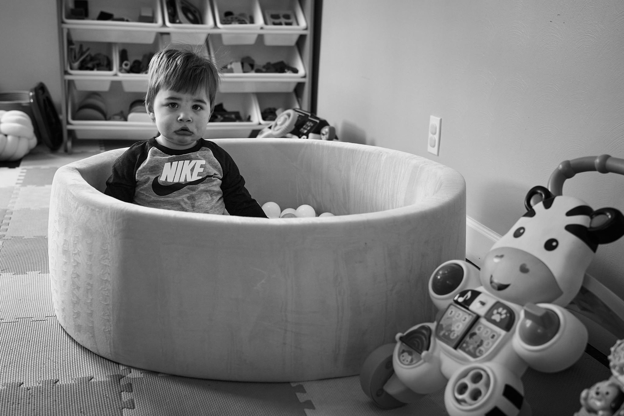Black and white photo of my grandson sitting in his ball pit
