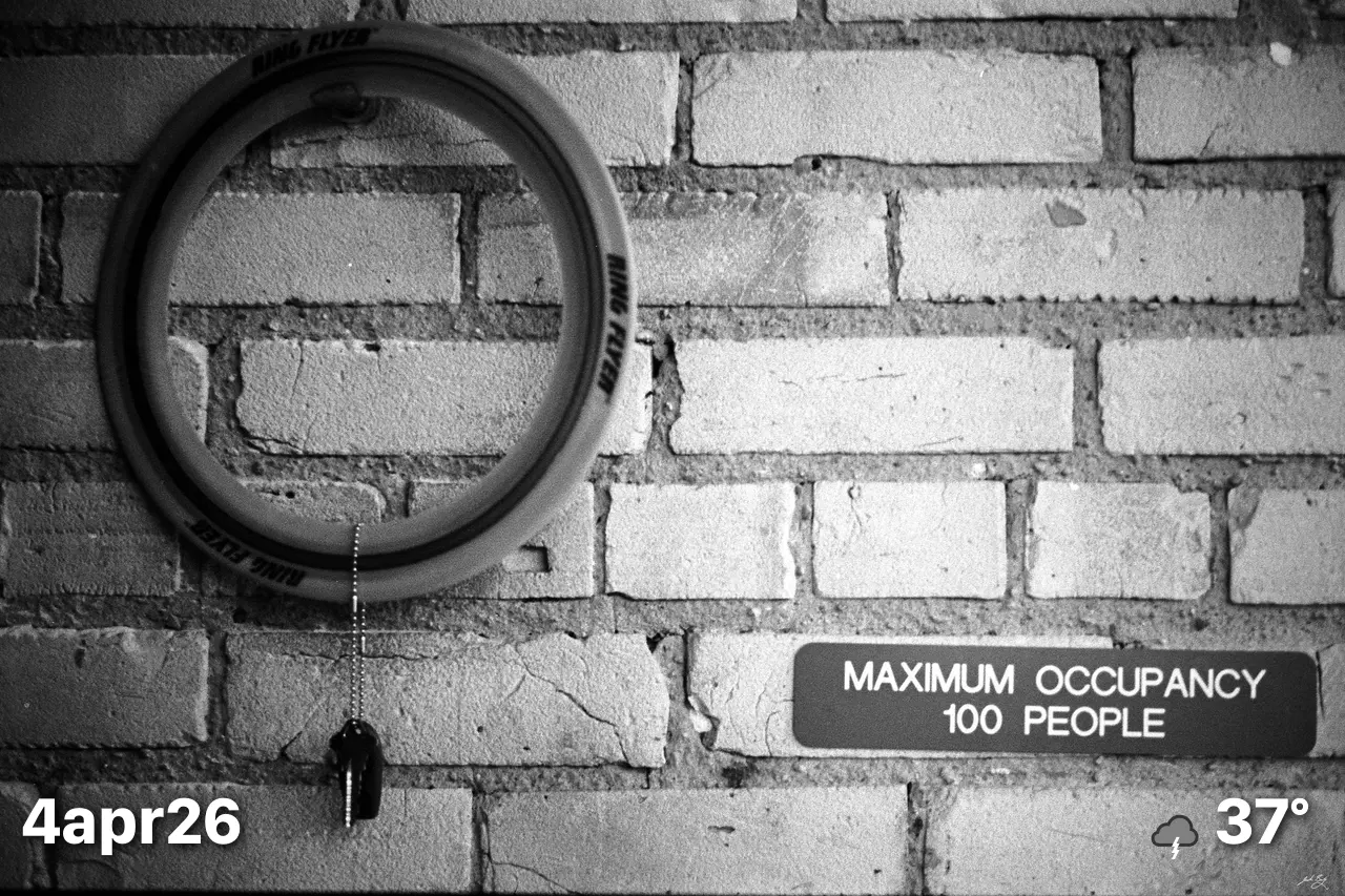 Key hanging on wall next to maximum occupancy sign
