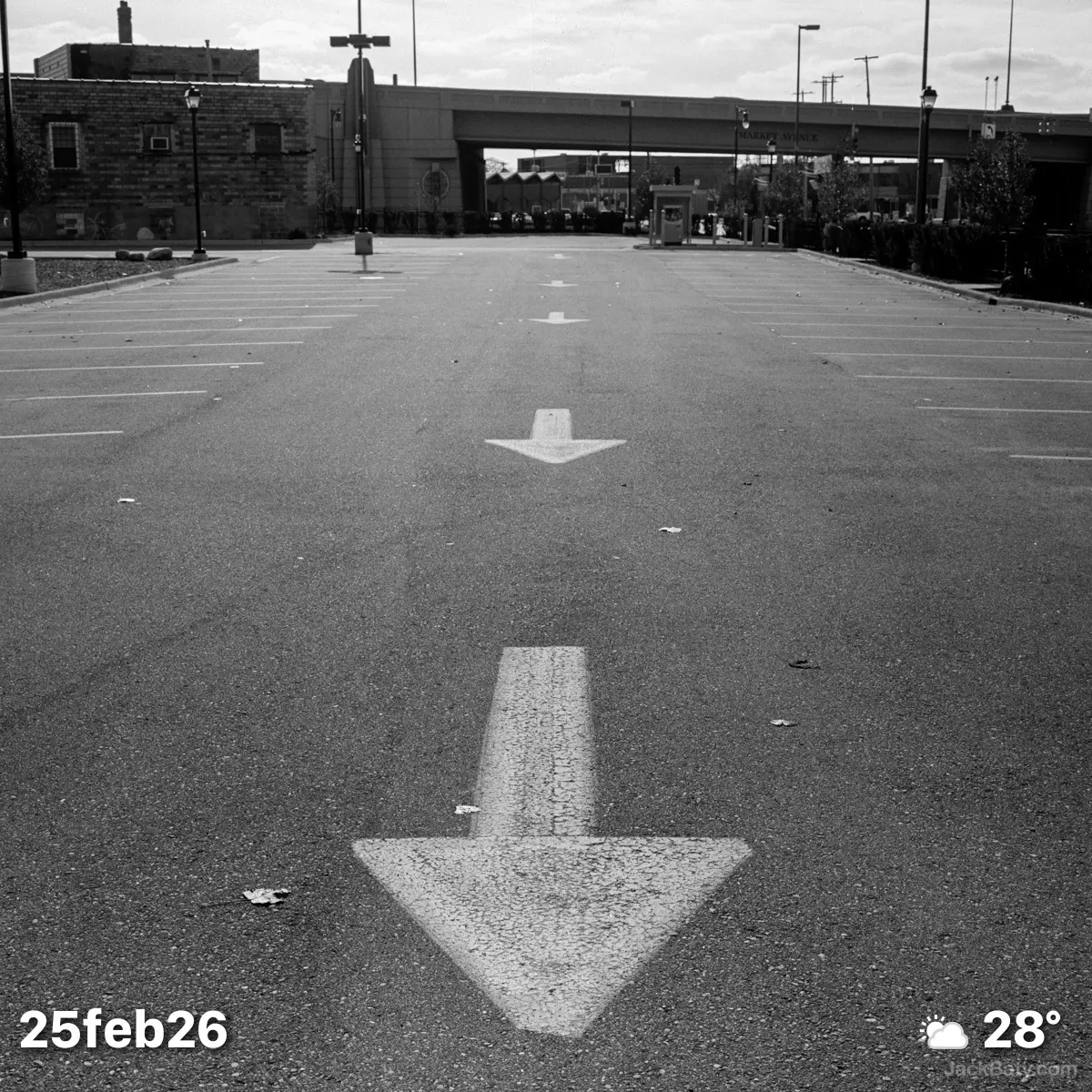 Black and white photo of parking lot with painted arrows
