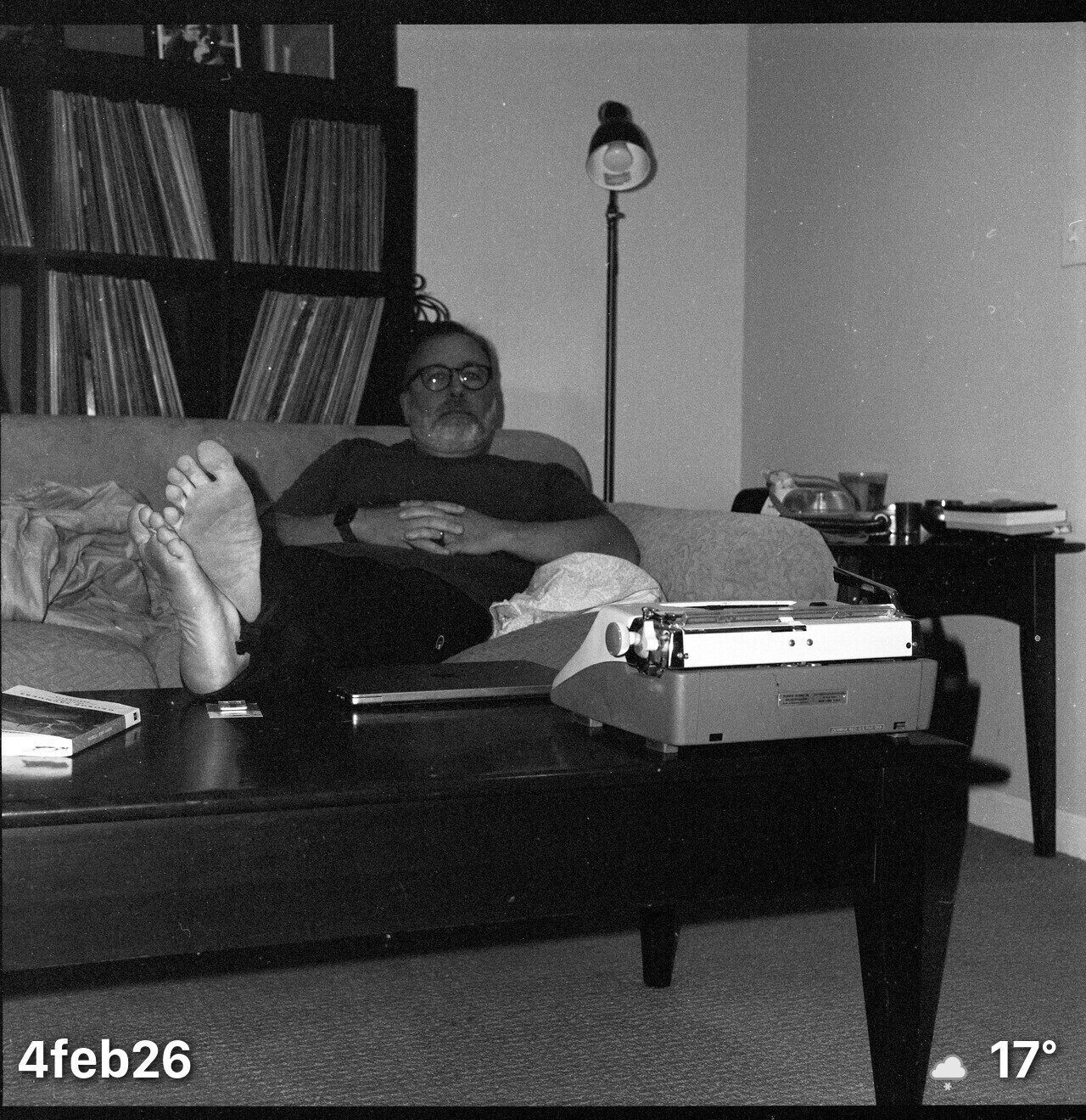 Black and white film photo of me sitting on the basement couch