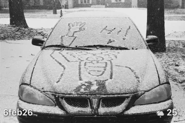 Car with Don Martin character saying Hi drawn in snow