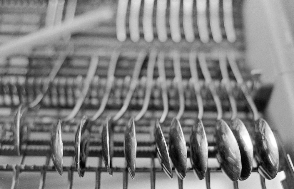 Black and white photo of spoons in dishwasher