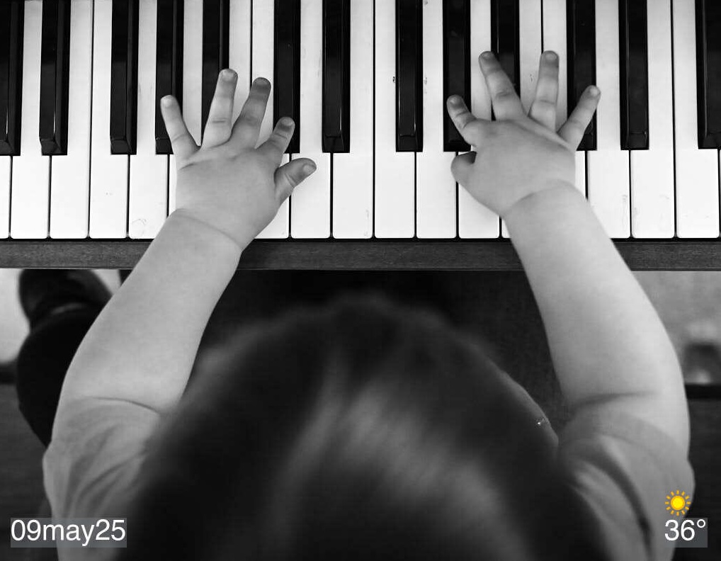 Black and white photo of child playing piano